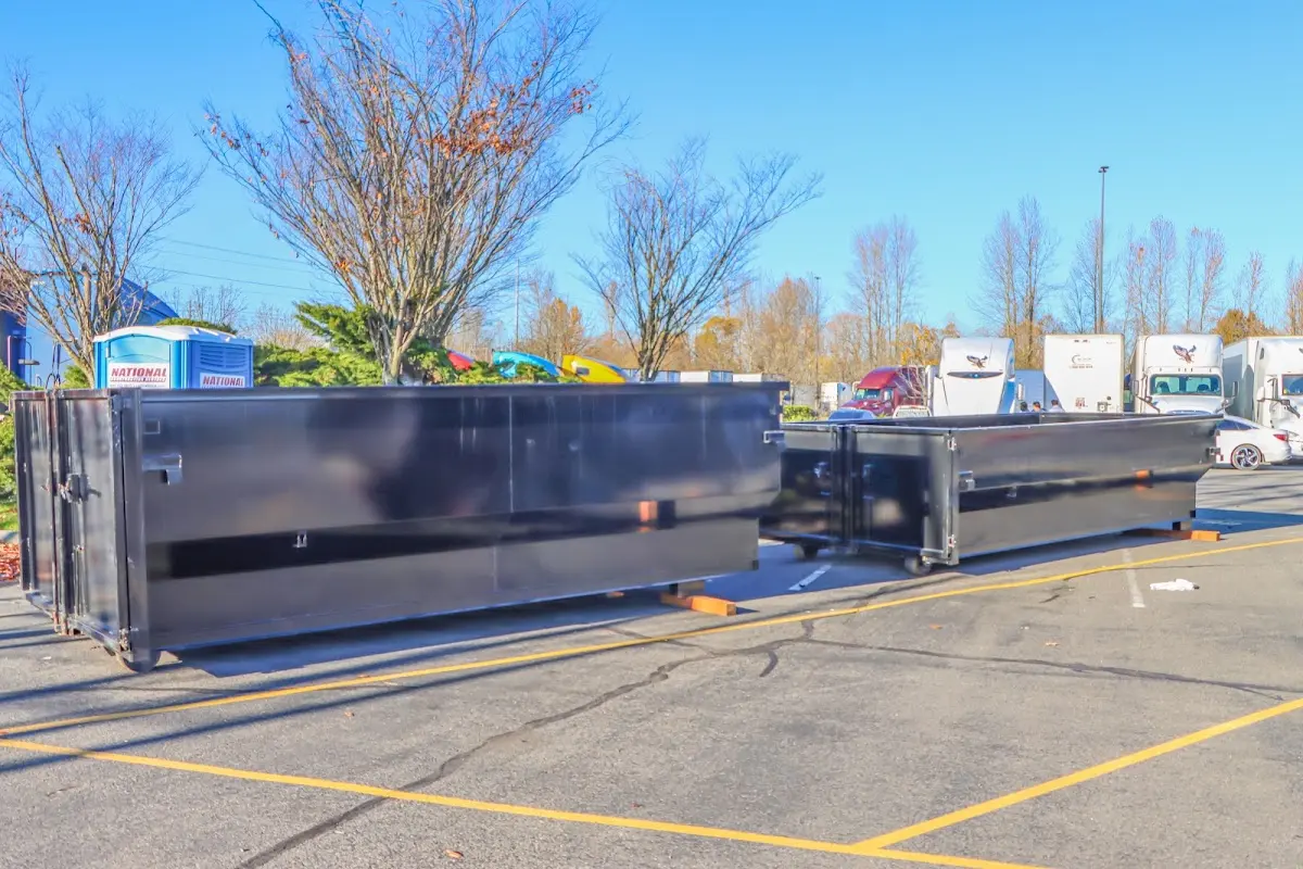 Professional dumpster rental service with roll-off container on residential driveway in Tisbury